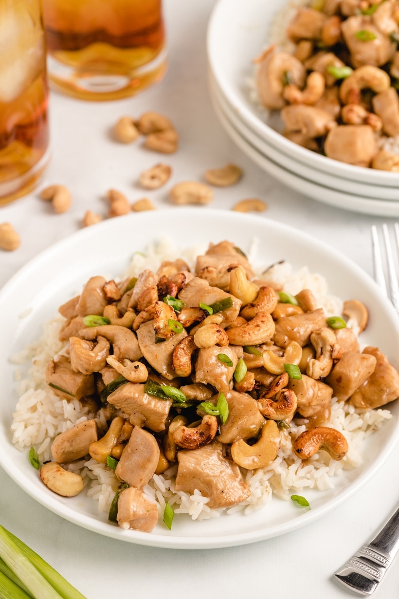 Kung Pao Chicken served over rice. kung pao chicken served on a white plate
