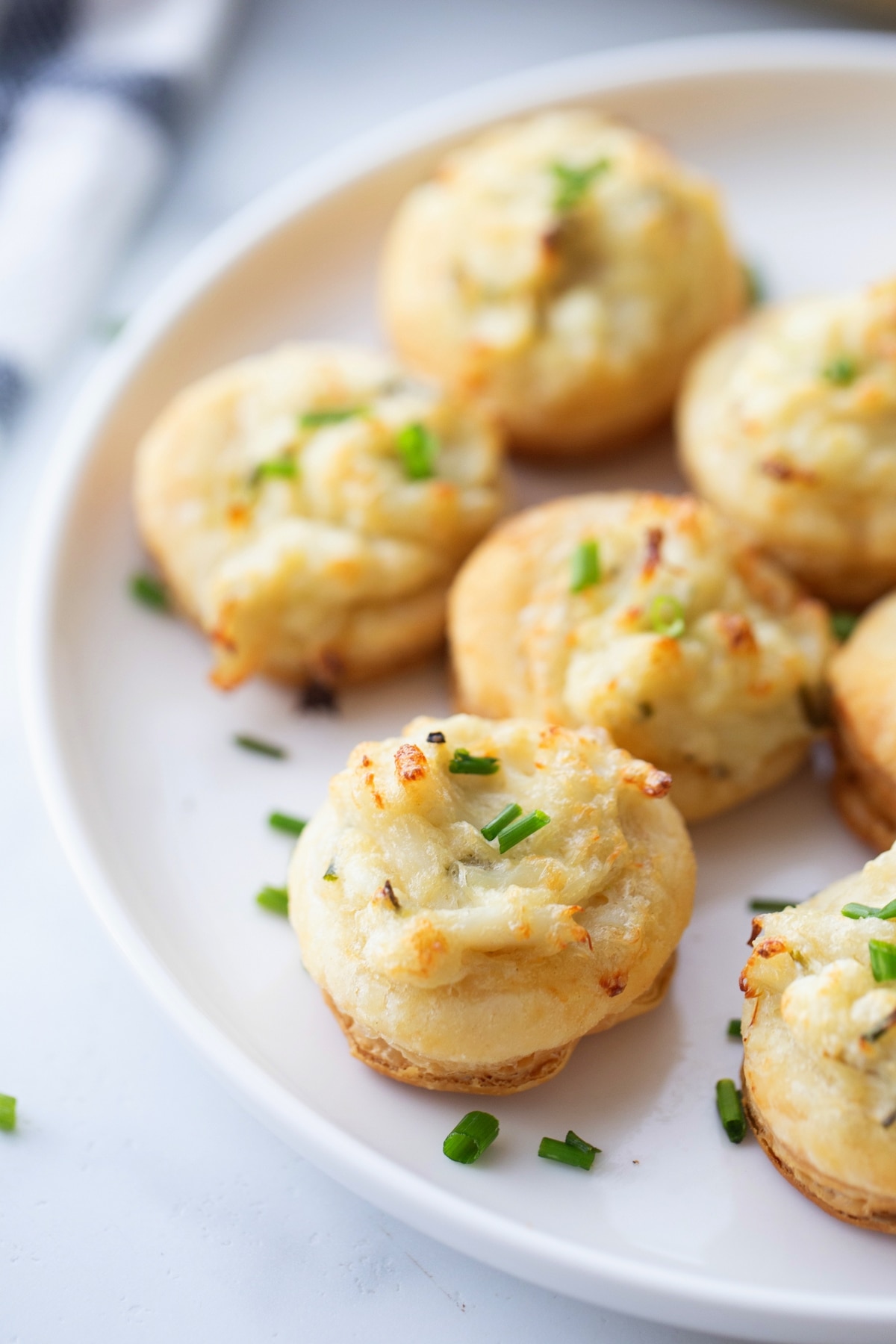 A serving of crab and chive puffs arranged on a white plate, ready to enjoy.