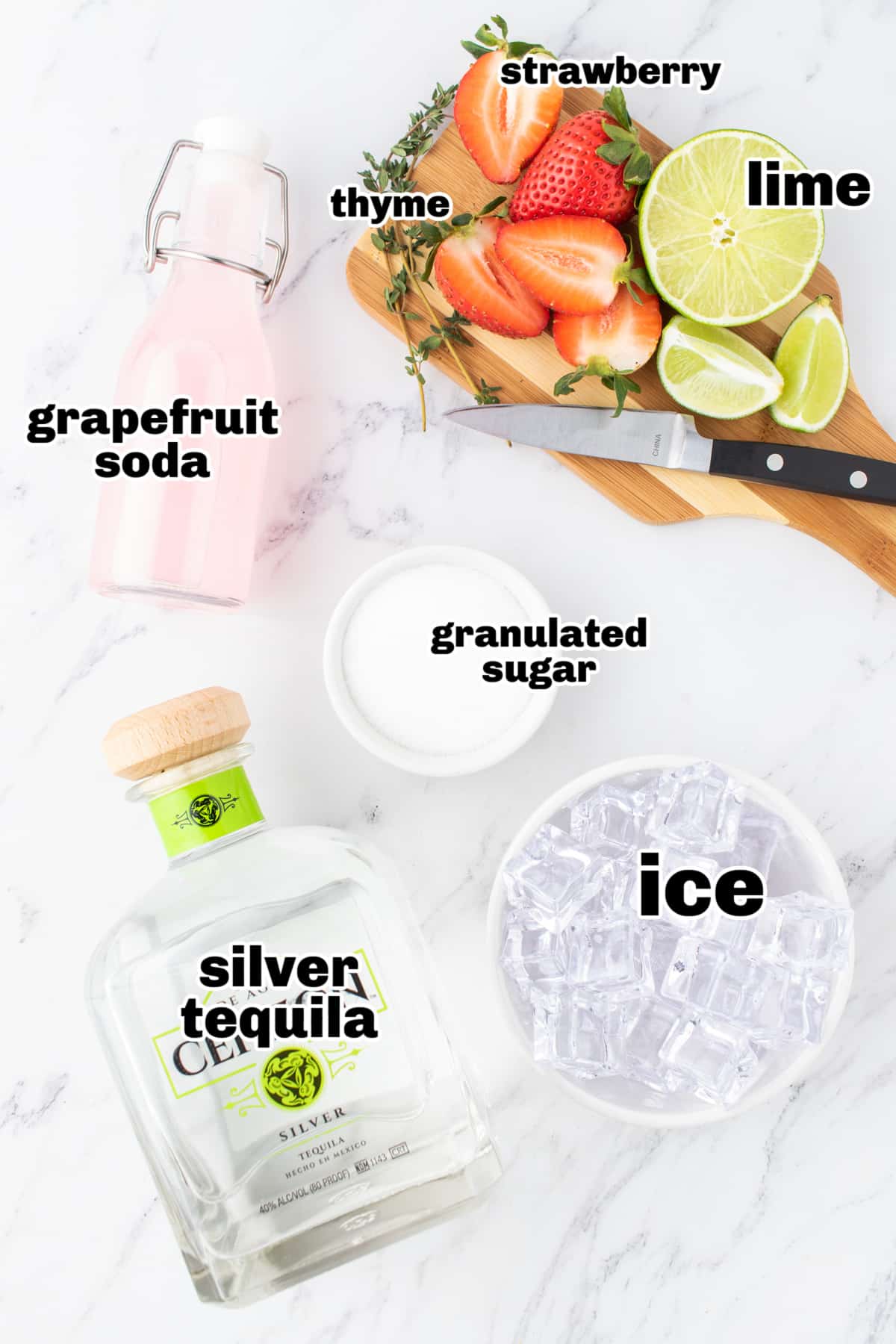 Strawberry Grapefruit Paloma ingredients Overhead shot of ingredients for the paloma, including strawberries, lime, tequila, and grapefruit soda.