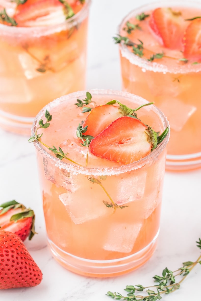 Strawberry Grapefruit Paloma ready to enjoy Three strawberry grapefruit palomas served in glasses with ice, garnished and ready to drink.