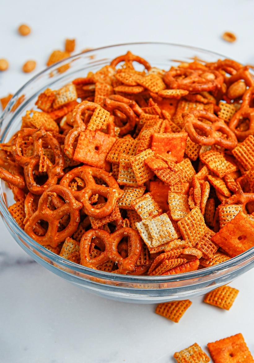 Chex mix in a serving bowl. Chex mix in a clear round bowl, ready to be served.