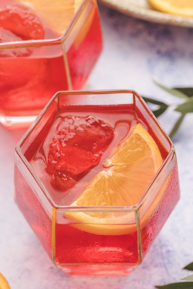 Negroni cocktails made with the best gin and a better balance Multiple Negroni cocktails made with the best gin and a smoother ratio, garnished with orange wedges.