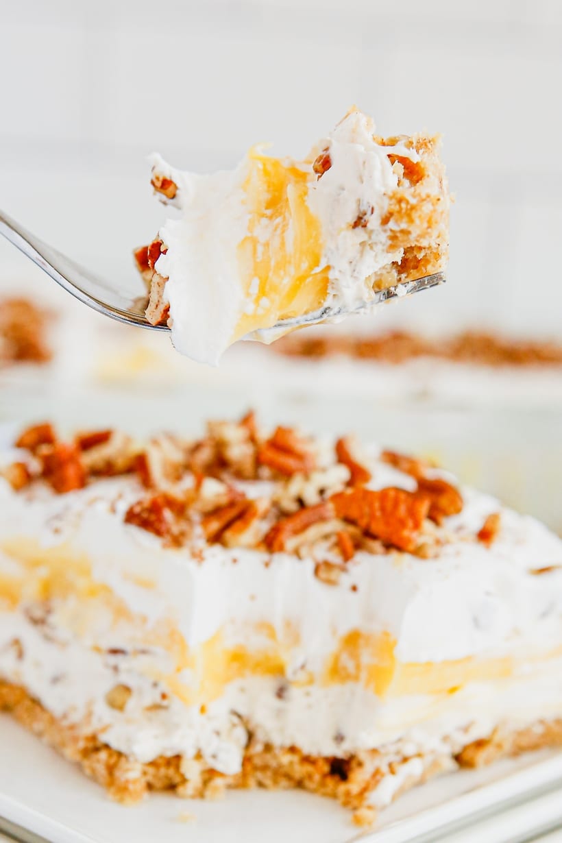 Fork with a Bite of Pecan Cream Pie Lush Close-up of a fork holding a bite of Pecan Cream Pie Lush, highlighting the creamy layers and pecan topping.
