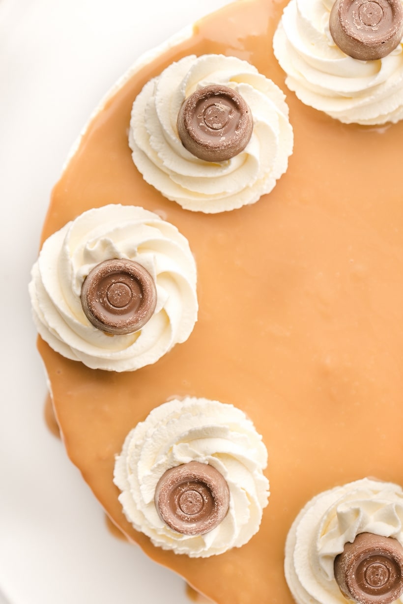 Top view of Rolo No-Bake Cheesecake Top view of the complete Rolo No-Bake Cheesecake with whipped cream swirls and Rolo candy on top.