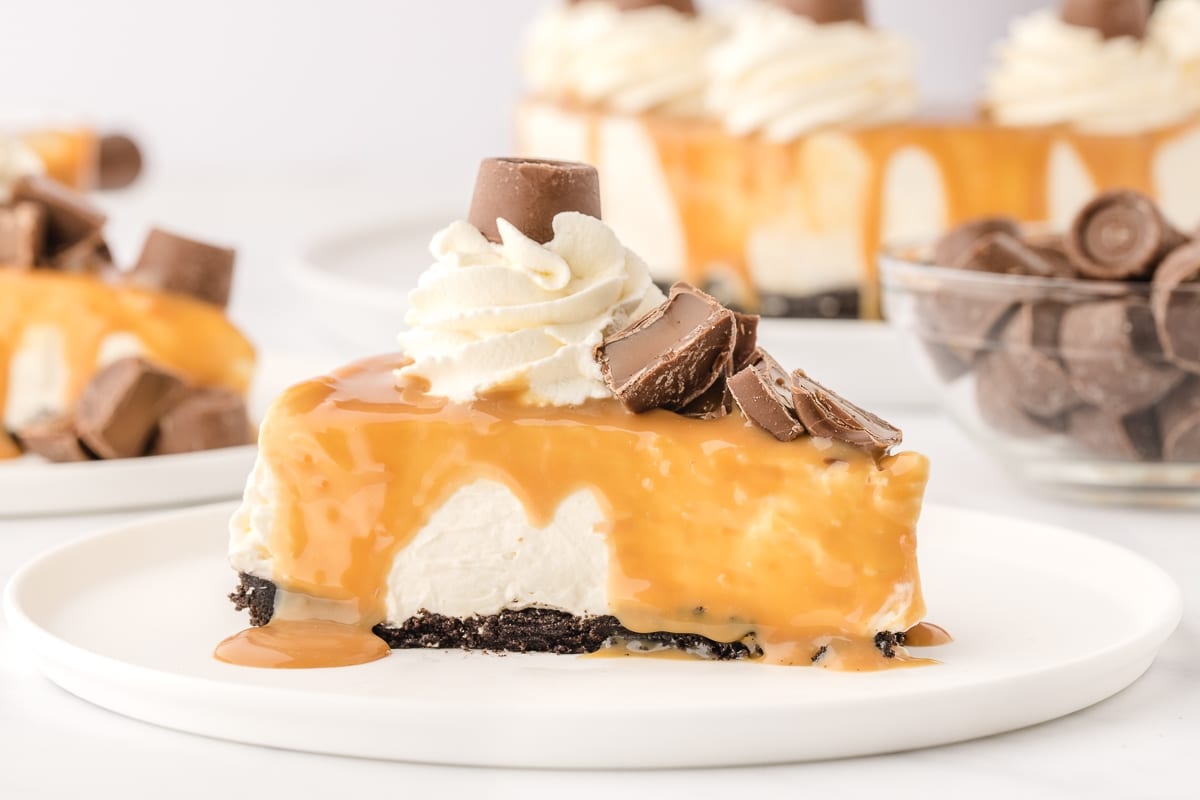 Slice of Rolo No-Bake Cheesecake with caramel dripping A slice of Rolo No-Bake Cheesecake with caramel topping dripping down the sides.