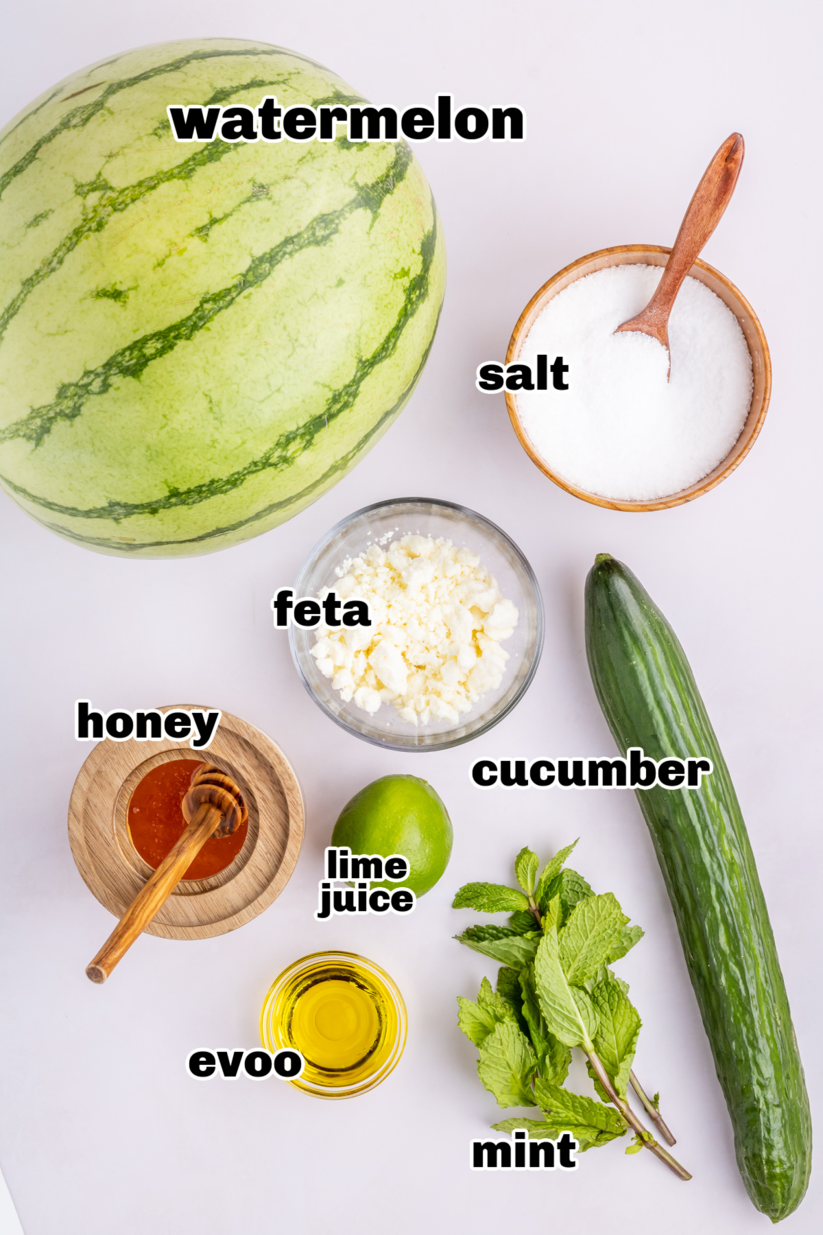 Ingredients for watermelon mint salad with cucumber, feta, and dressing Overhead view of prepped ingredients for watermelon feta mint salad