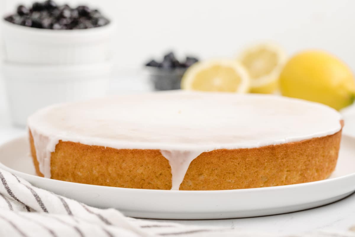 A whole Lemon Cornmeal Cake with lemon glaze Side view of the whole lemon cornmeal cake with glossy lemon glaze on top.