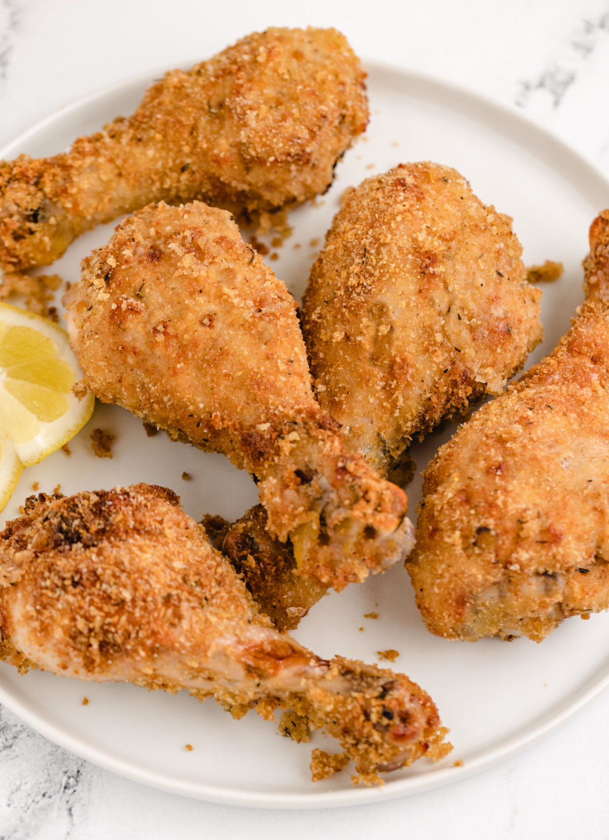 Crispy Lemon Chicken Drumsticks crispy lemon chicken drumsticks with golden panko crust served on a white plate with lemon