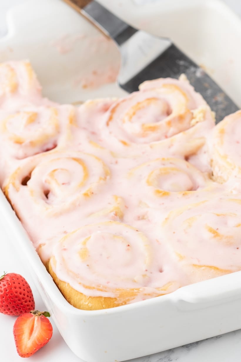 Strawberry Sweet Rolls being removed from pan Lifting a warm strawberry sweet roll out of the pan with an offset spatula.