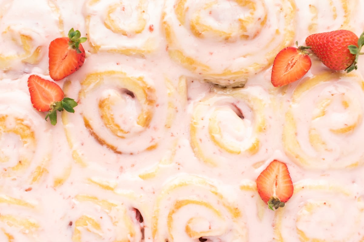 close up Strawberry Sweet Rolls Close-up shot of glazed strawberry sweet rolls highlighting the glossy glaze and textured swirl.