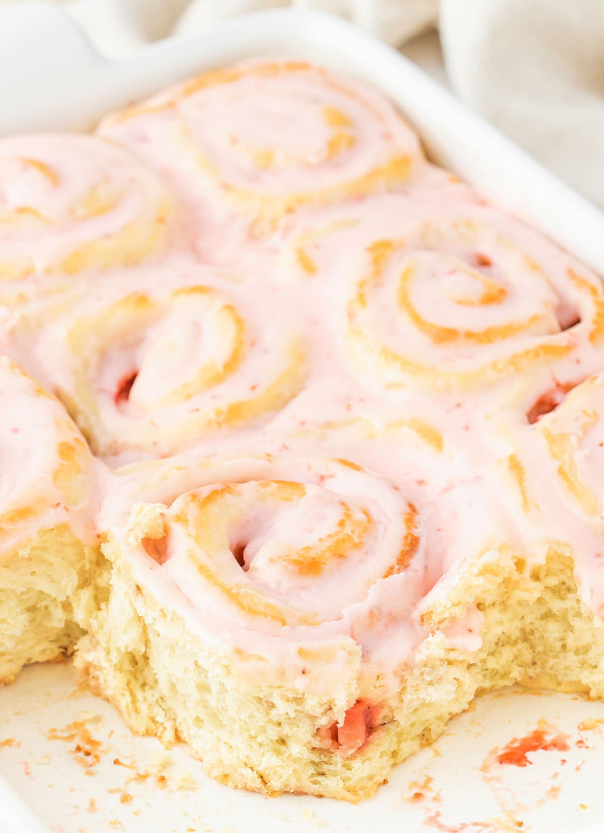 Strawberry Sweet Rolls in a baking pan Overhead view of a pan of baked strawberry sweet rolls with a few removed, showing the soft, jammy centers.
