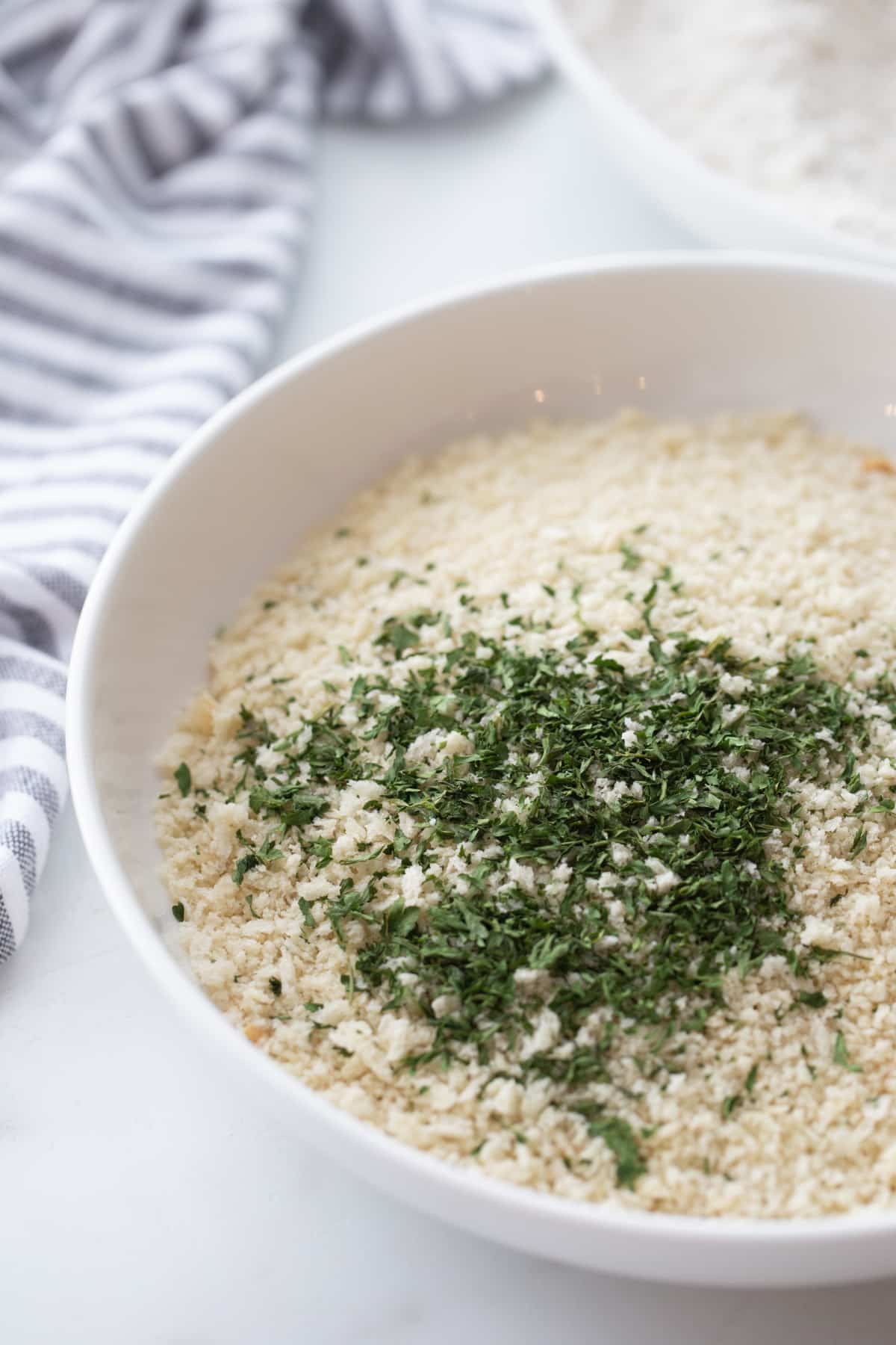 Chicken Tenderloin Piccata coating A white bowl filled with seasoned panko breadcrumbs, ready for coating the chicken tenderloins.