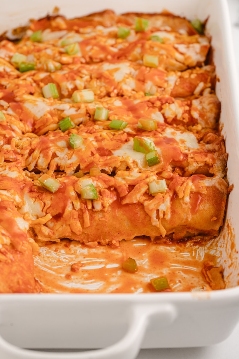 These buffalo chicken enchiladas are a triple cheesy blend of fiery flavors, packed with shredded chicken, a zesty buffalo sauce, and lots of tortillas, all baked to perfection. Each bite delivers a punch of flavor that's downright addictive. This enchilada dinner is perfect for game day at home or for tailgating. They also make a great weeknight dinner. buffalo chicken enchiladas