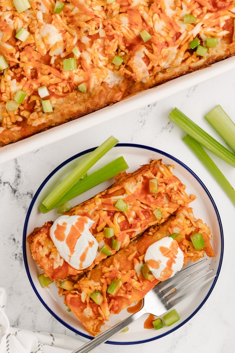 These buffalo chicken enchiladas are the creamiest, triple cheesy blend of fiery flavors, packed with shredded chicken, a zesty buffalo sauce, and lots of tortillas, all baked to perfection. Each bite delivers a punch of flavor that's downright addictive. This enchilada dinner is perfect for game day at home or for tailgating. They also make a great weeknight dinner. chicken enchiladas buffalo style