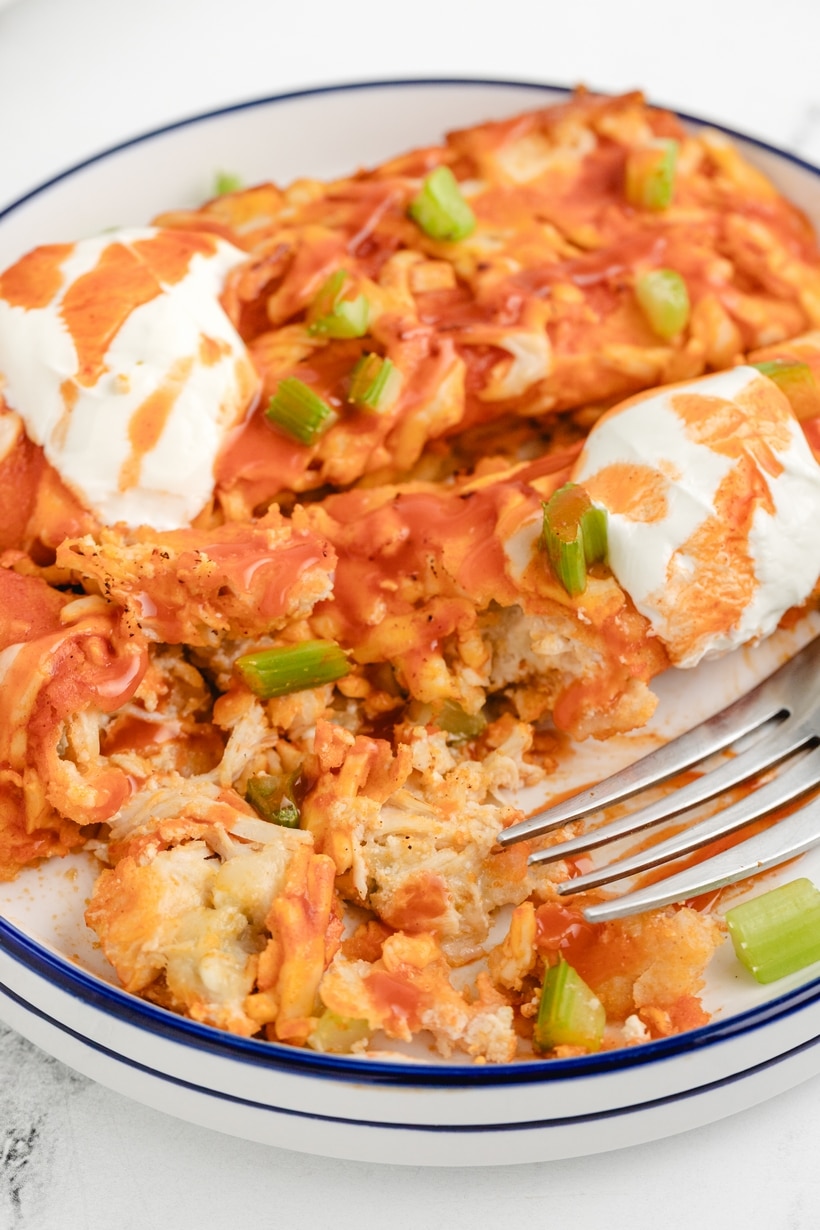 These buffalo chicken enchiladas are the creamiest, triple cheesy blend of fiery flavors, packed with shredded chicken, a zesty buffalo sauce, and lots of tortillas, all baked to perfection. Each bite delivers a punch of flavor that's downright addictive. This enchilada dinner is perfect for game day at home or for tailgating. They also make a great weeknight dinner. enchiladas
