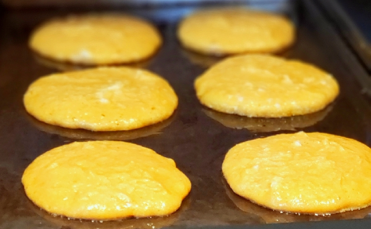 Pumpkin pancakes on griddle. Pumpkin pancake batter cooking on a hot griddle.