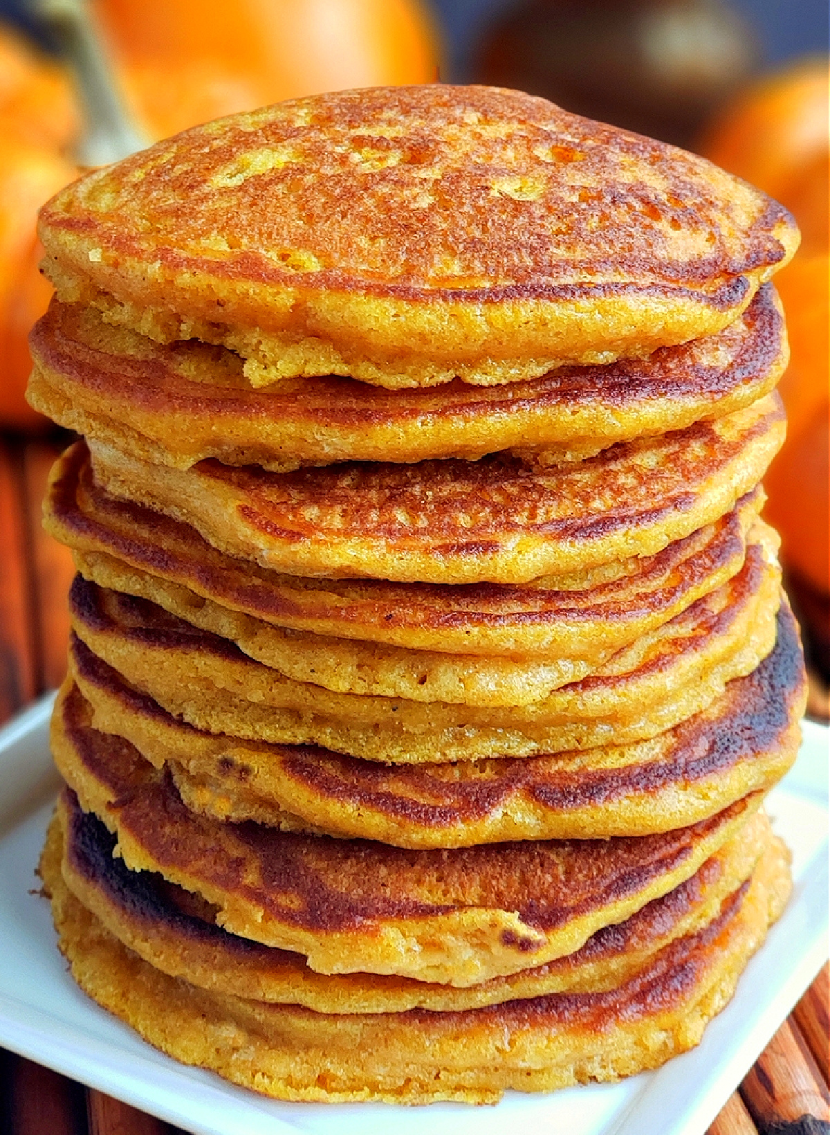 Homemade pumpkin pancakes stack. Homemade pumpkin pancakes stacked on a white plate.