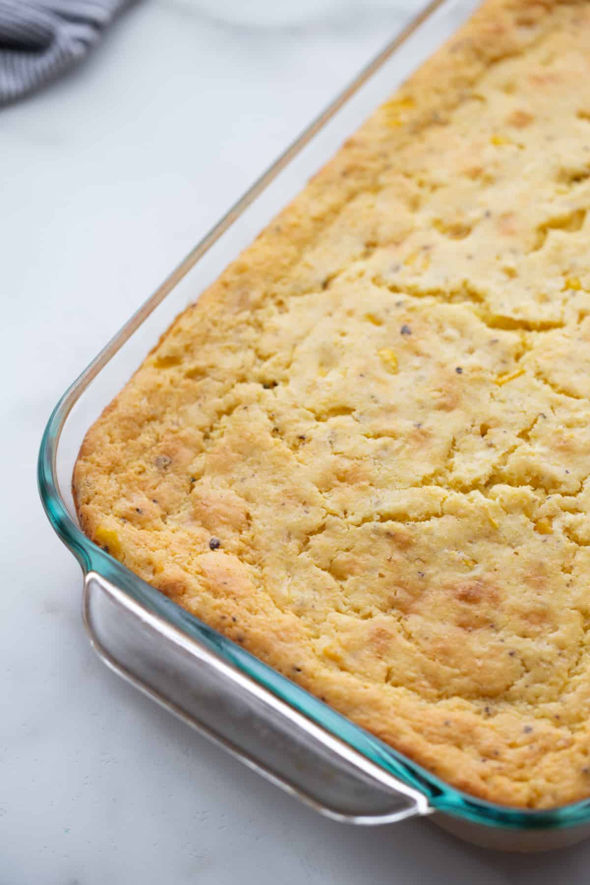 Baked corn pudding Freshly baked corn pudding in a 9x13-inch casserole dish, still warm and golden, before cinnamon is added.