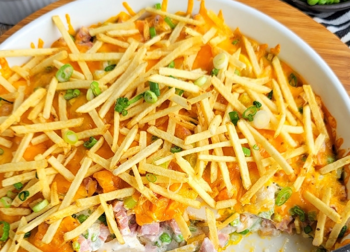Overhead view of the casserole with half removed, showing the creamy filling and cheesy topping.