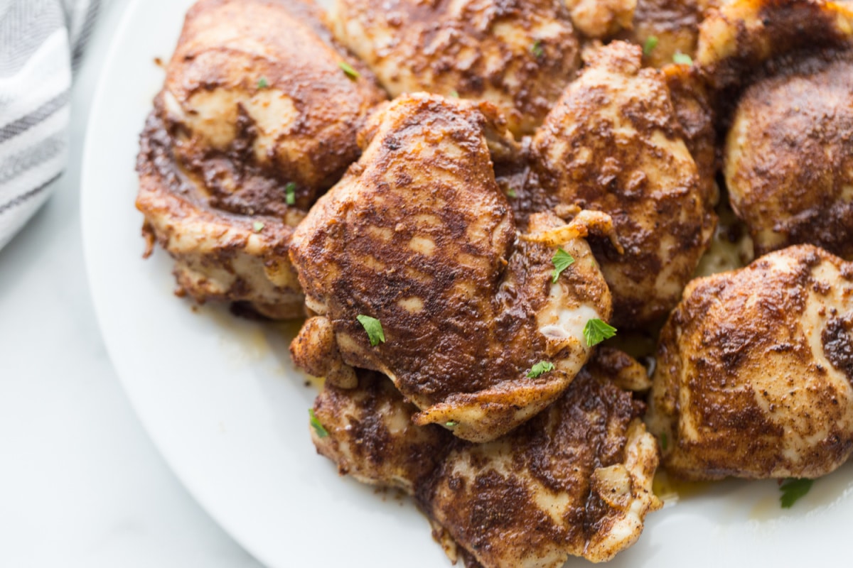 Air Fryer Caribbean Spiced Chicken with parsley Top view of Air Fryer Caribbean Spiced Chicken arranged on a platter, showcasing its rich color and seasoning.