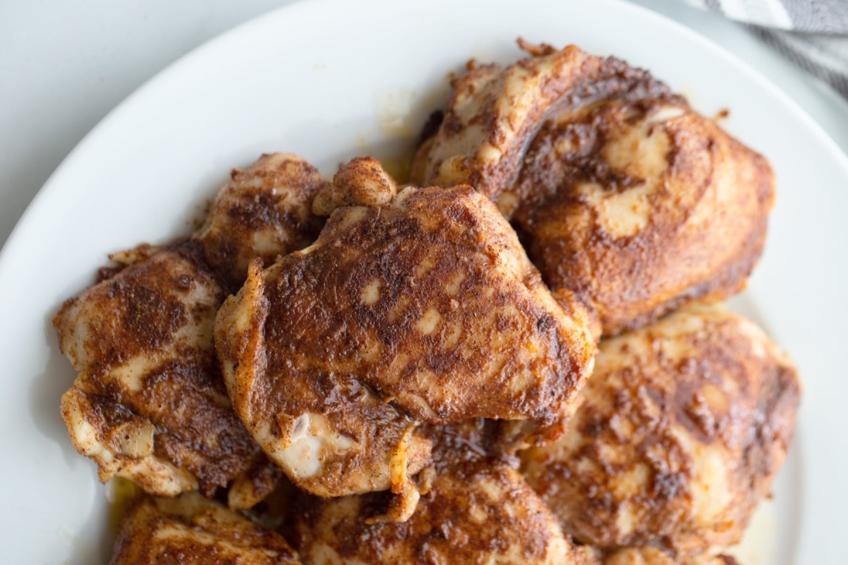 Air Fryer Caribbean Spiced Chicken plated Top view of whole pieces of Air Fryer Caribbean Spiced Chicken on a white platter.