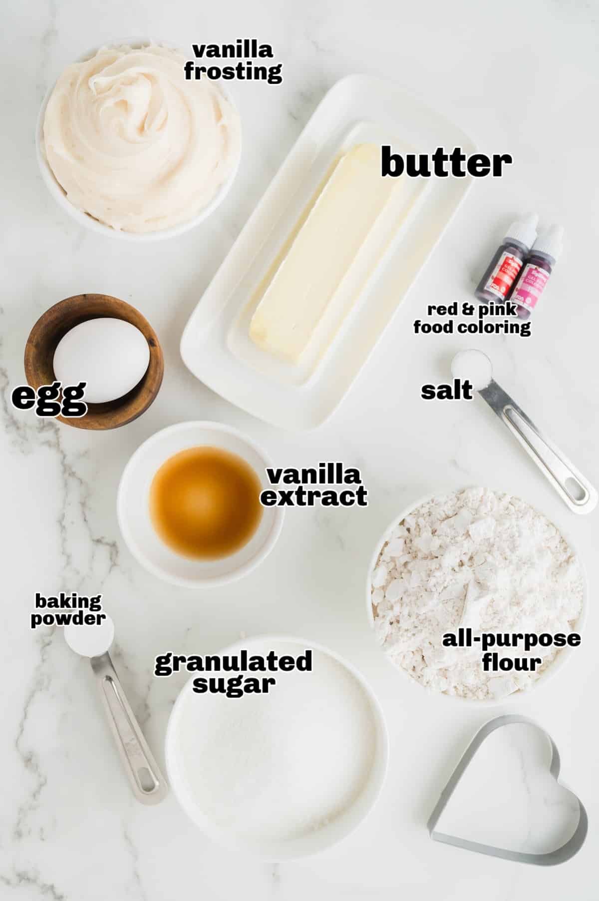 A flat lay of ingredients including butter, sugar, flour, and food coloring, arranged for making the cookies.