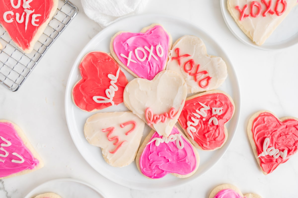 A variety of decorated heart sugar cookies spread out on a cooling rack, ready to be enjoyed.