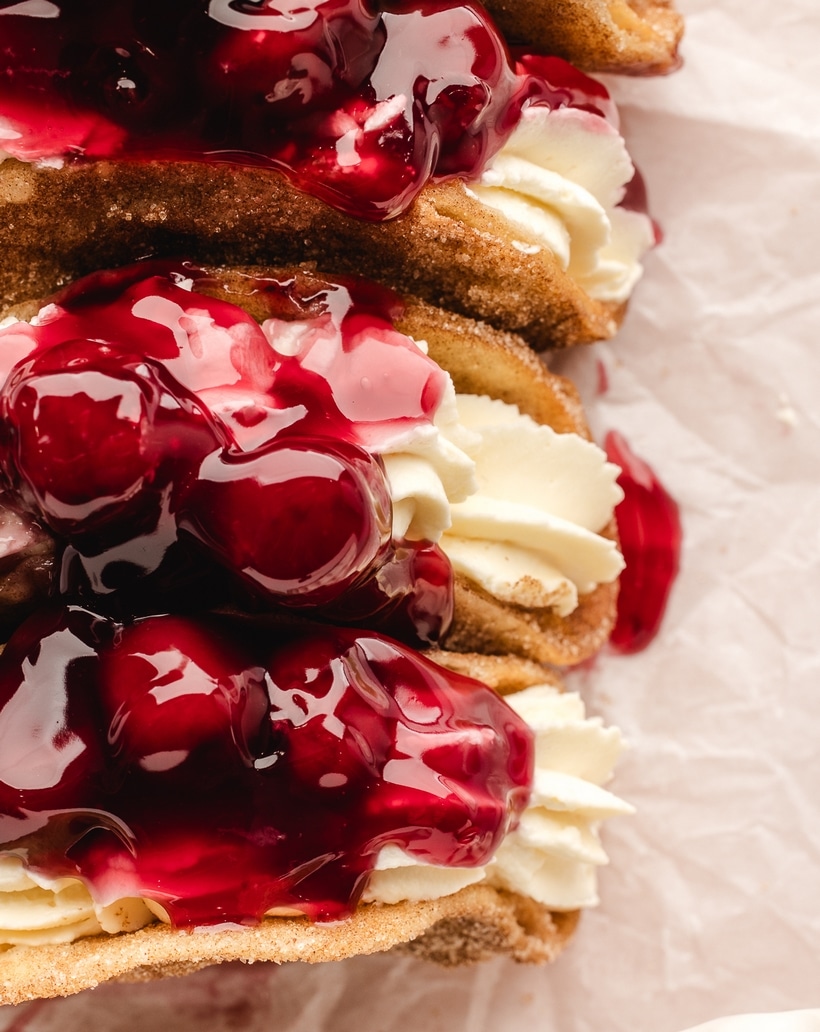 Cherry Cheesecake Taco Filled and Ready to Serve Overhead view of a cherry cheesecake taco filled with whipped cheesecake and topped with cherry pie filling.