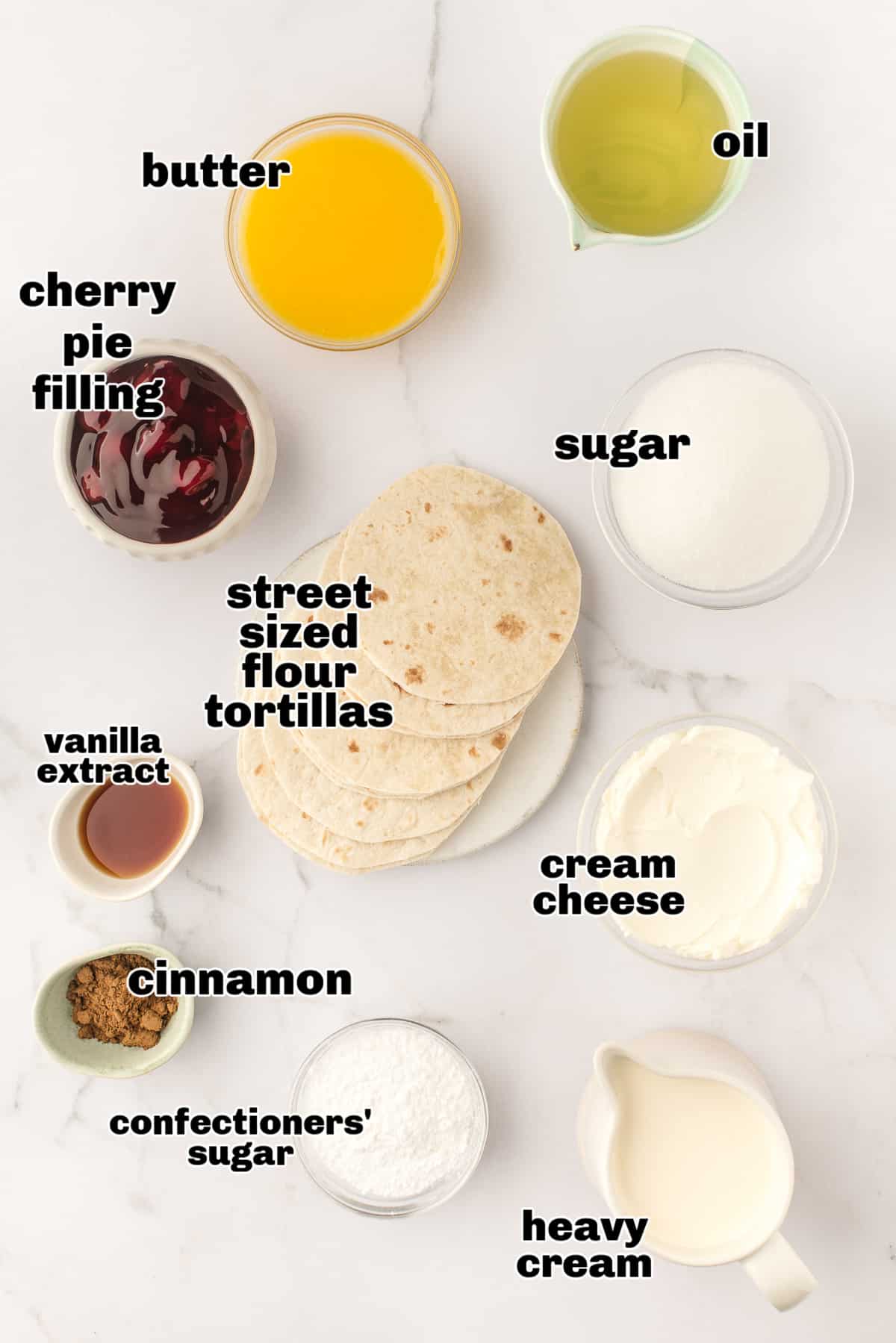 Ingredients for Cherry Cheesecake Tacos Ingredients for cherry cheesecake tacos including tortillas, cream cheese, heavy cream, cherry pie filling, and cinnamon sugar.