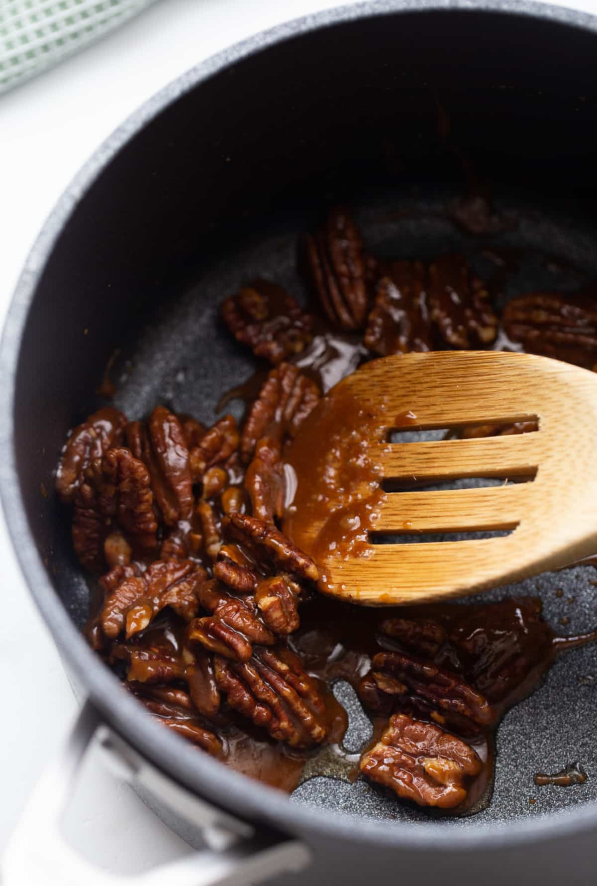 Candied pecans cooking for brownie topping Pecan halves coated in brown sugar and butter, cooking in a small saucepan