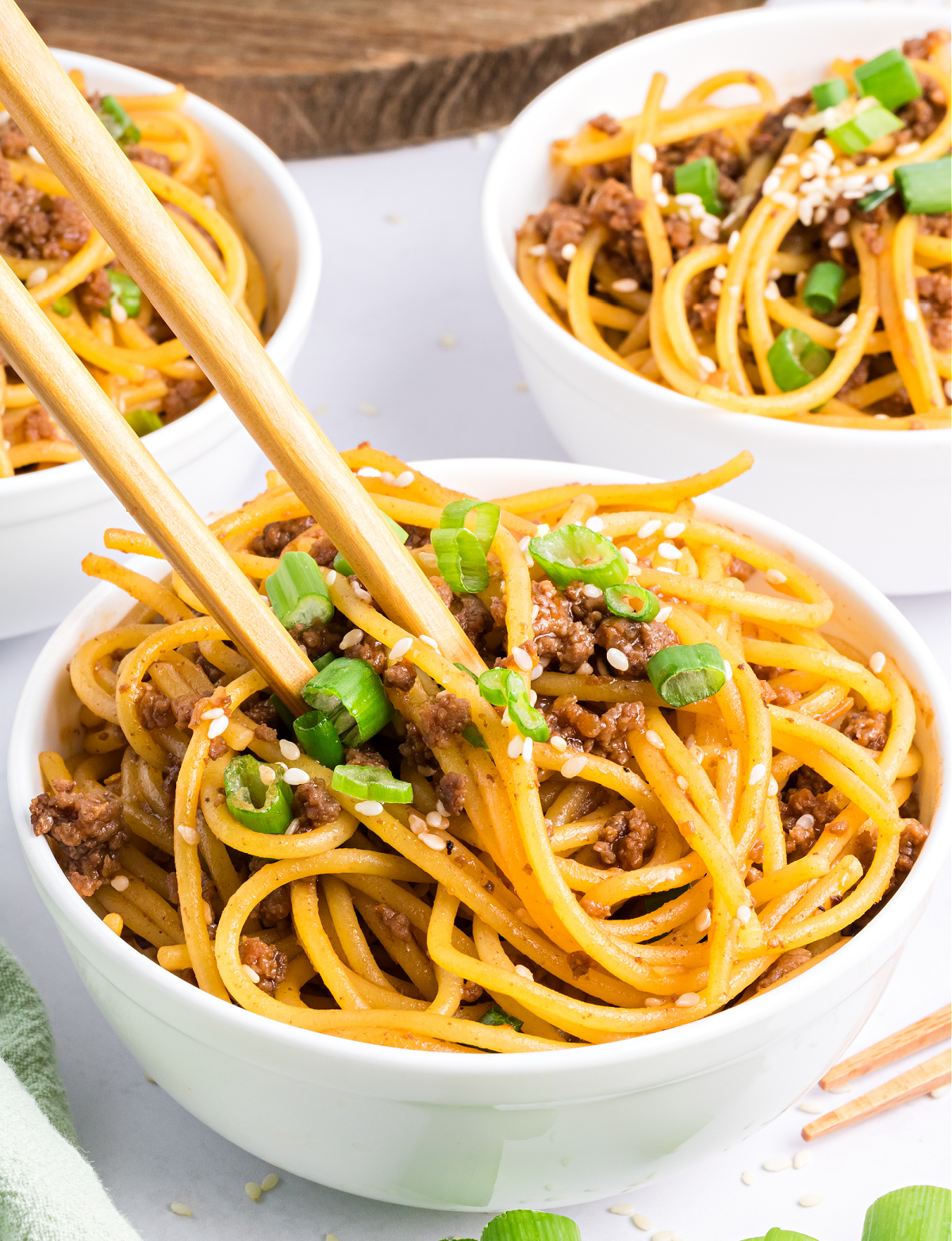 Mongolian beef with noodles Mongolian beef with noodles coated in hoisin soy glaze, garnished with sesame seeds and green onions.
