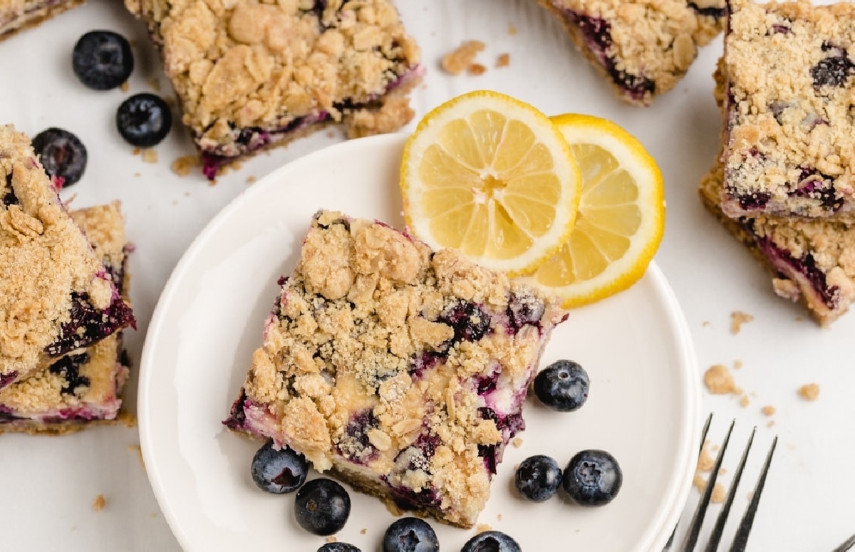 Baked lemon blueberry bars with lemon garnish Overhead view of lemon blueberry crumble bars with lemon slices