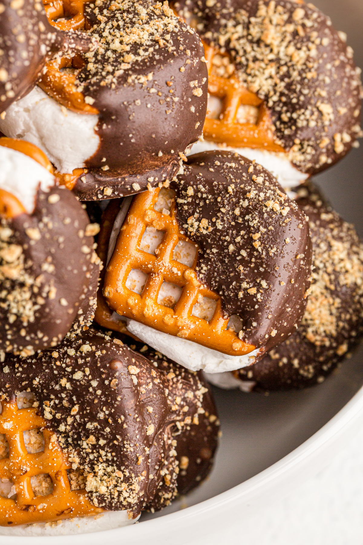 close-up of oven-baked pretzel s’mores bites with graham topping Close-up view of chocolate-dipped s’mores pretzels with golden graham crumbs