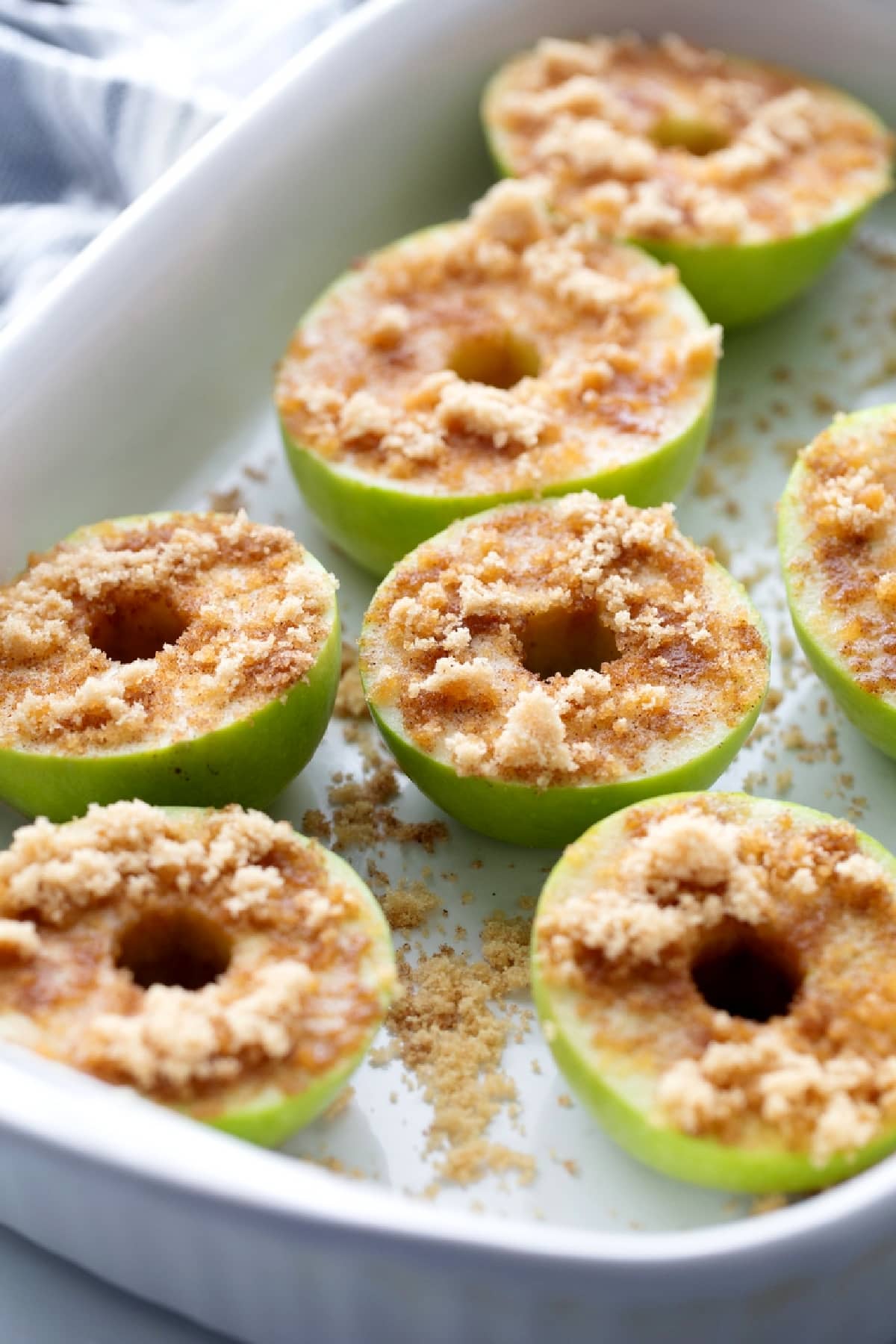 Granny Smith apple halves topped with brown sugar and cinnamon before baking