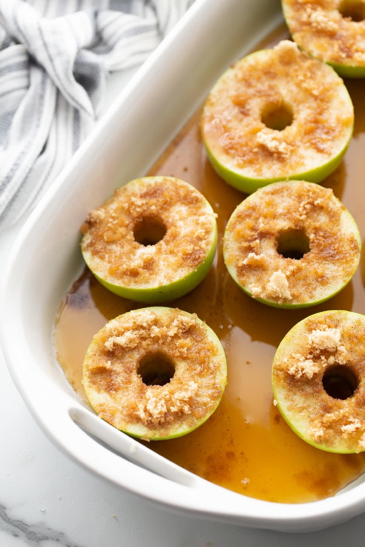 Baked apples with maple syrup and cinnamon prepared in a baking dish