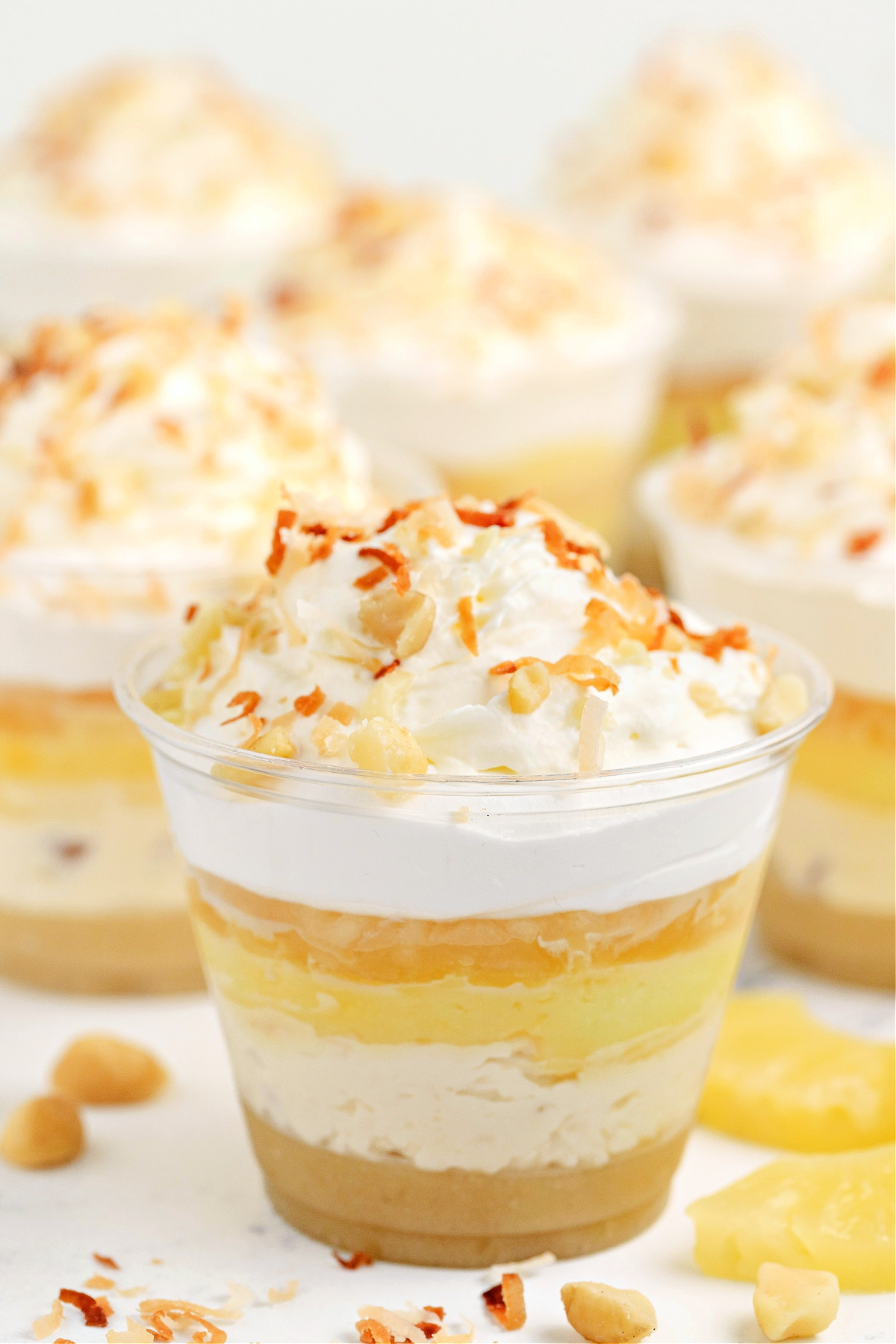 Hawaiian Dream Dessert Cups with pineapple, coconut, and macadamia layers Hawaiian Dream Dessert Cups layered with macadamia nut crust, coconut cream pudding, pineapple, and whipped topping, finished with toasted coconut and chopped macadamias by Noble Pig.