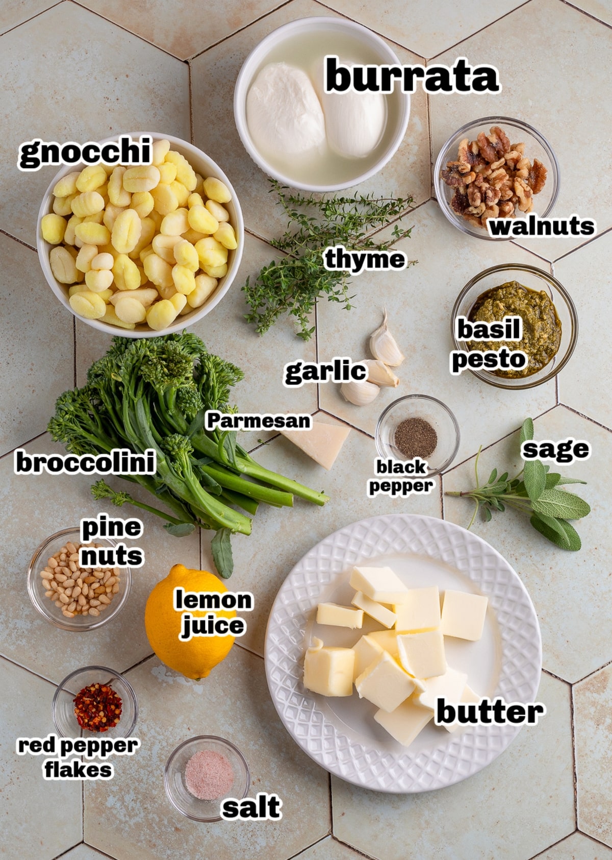 Ingredients for brown butter gnocchi with burrata and pesto. Overhead view of ingredients for gnocchi with burrata, pesto, and brown butter, including broccolini, walnuts, pine nuts, lemon, and fresh herbs.