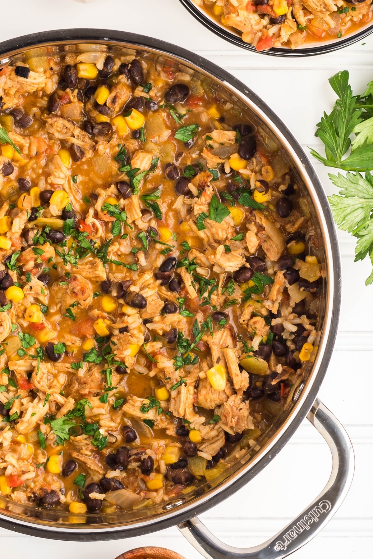 Southwest Turkey Skillet in a metal pan, garnished with fresh parsley Overhead view of southwest turkey skillet in a skillet.