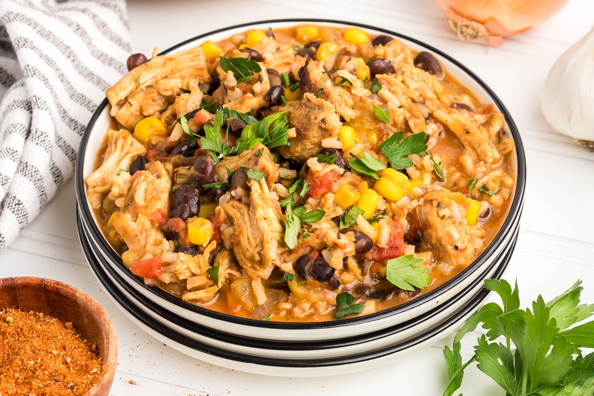 Close-up of cheesy Southwest Turkey Skillet highlighting black beans and corn Southwest turkey skillet serving on a white plate.