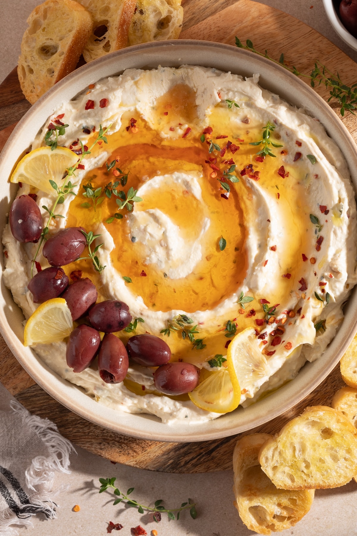 Whipped Feta Roasted Garlic Dip Overhead View Overhead view of whipped feta roasted garlic dip with honey and baguette.