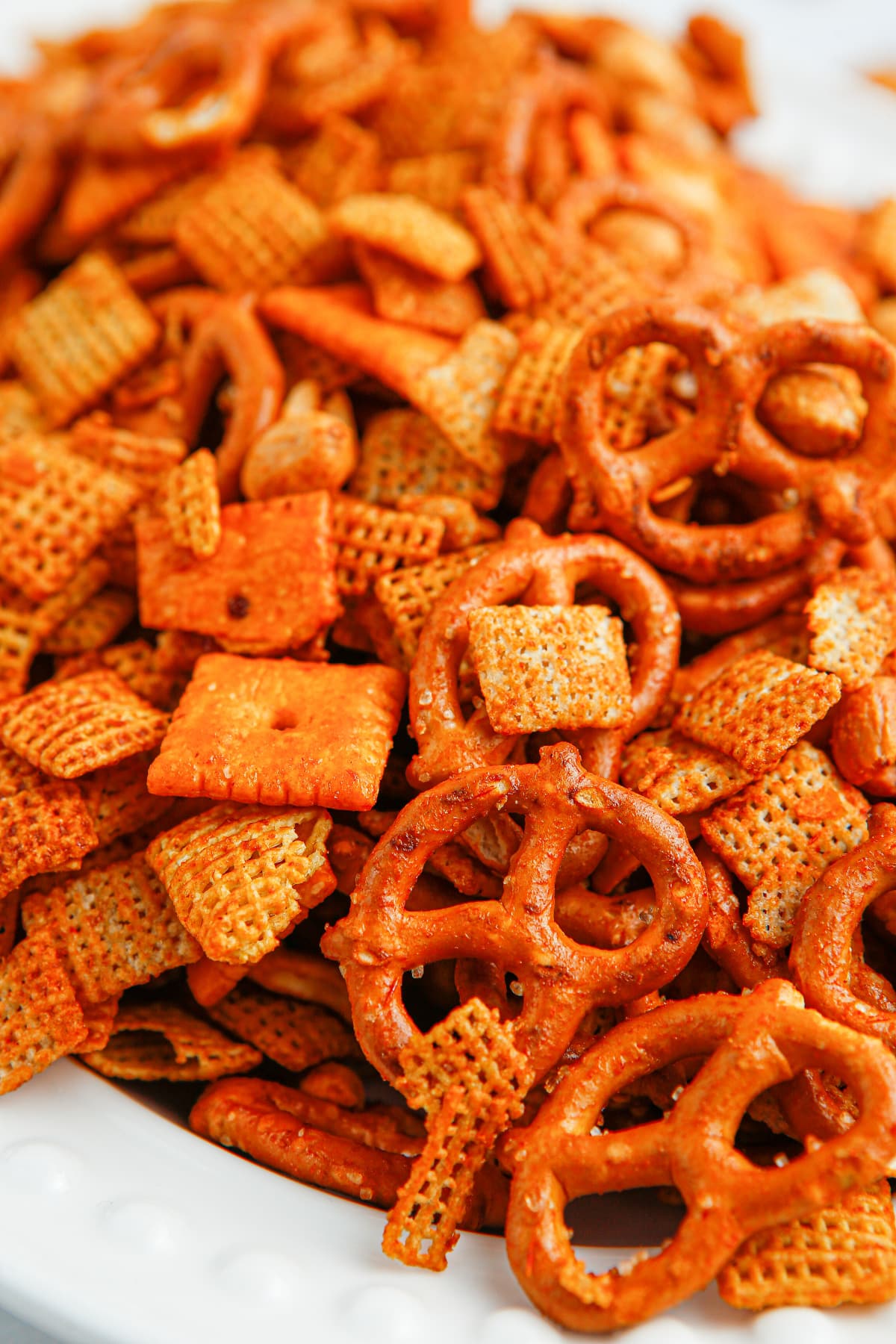 BBQ Chex mix coated with smoky barbecue seasoning Close-up of BBQ Chex snack mix with pretzels, Cheez-Its, peanuts and Chex cereal