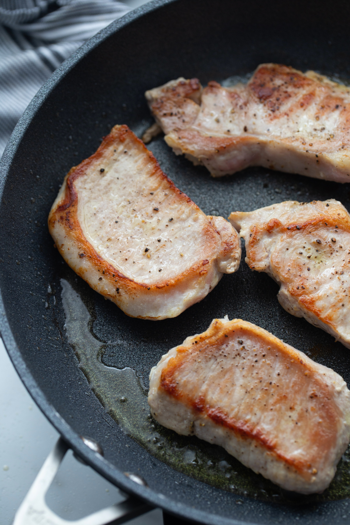 Boneless pork loin chops browning in a nonstick skillet for pork Marsala.