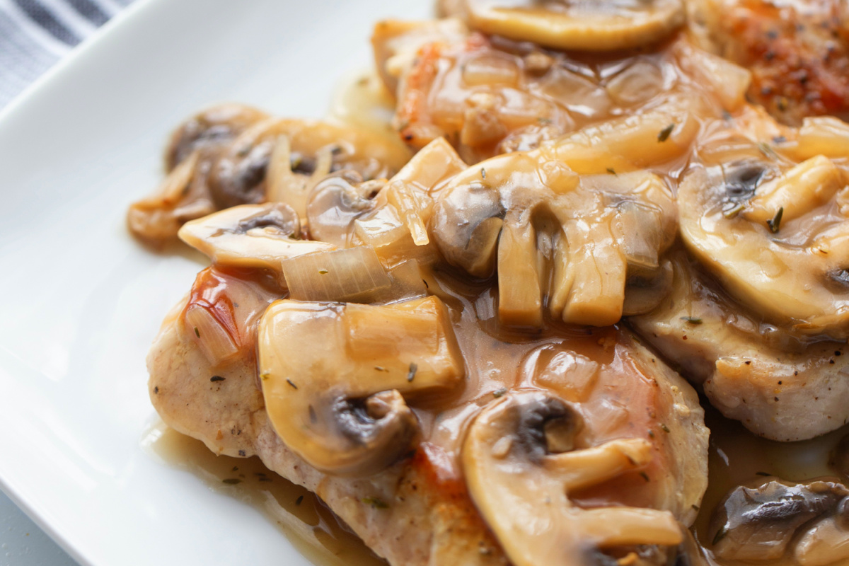 Close-up of pork Marsala with boneless pork chops, mushrooms, and Marsala sauce.
