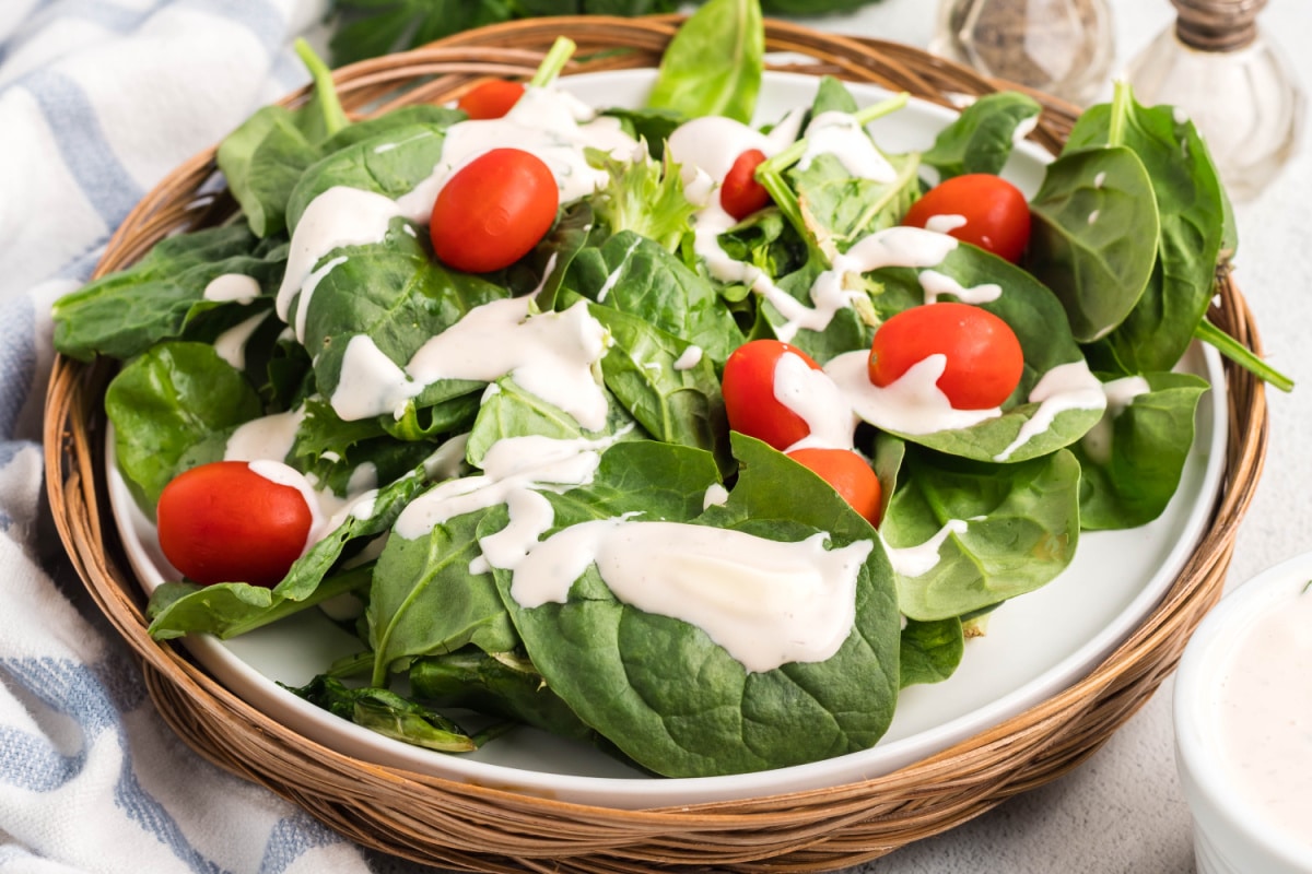 Fresh spinach greens topped with creamy mayonnaise salad dressing