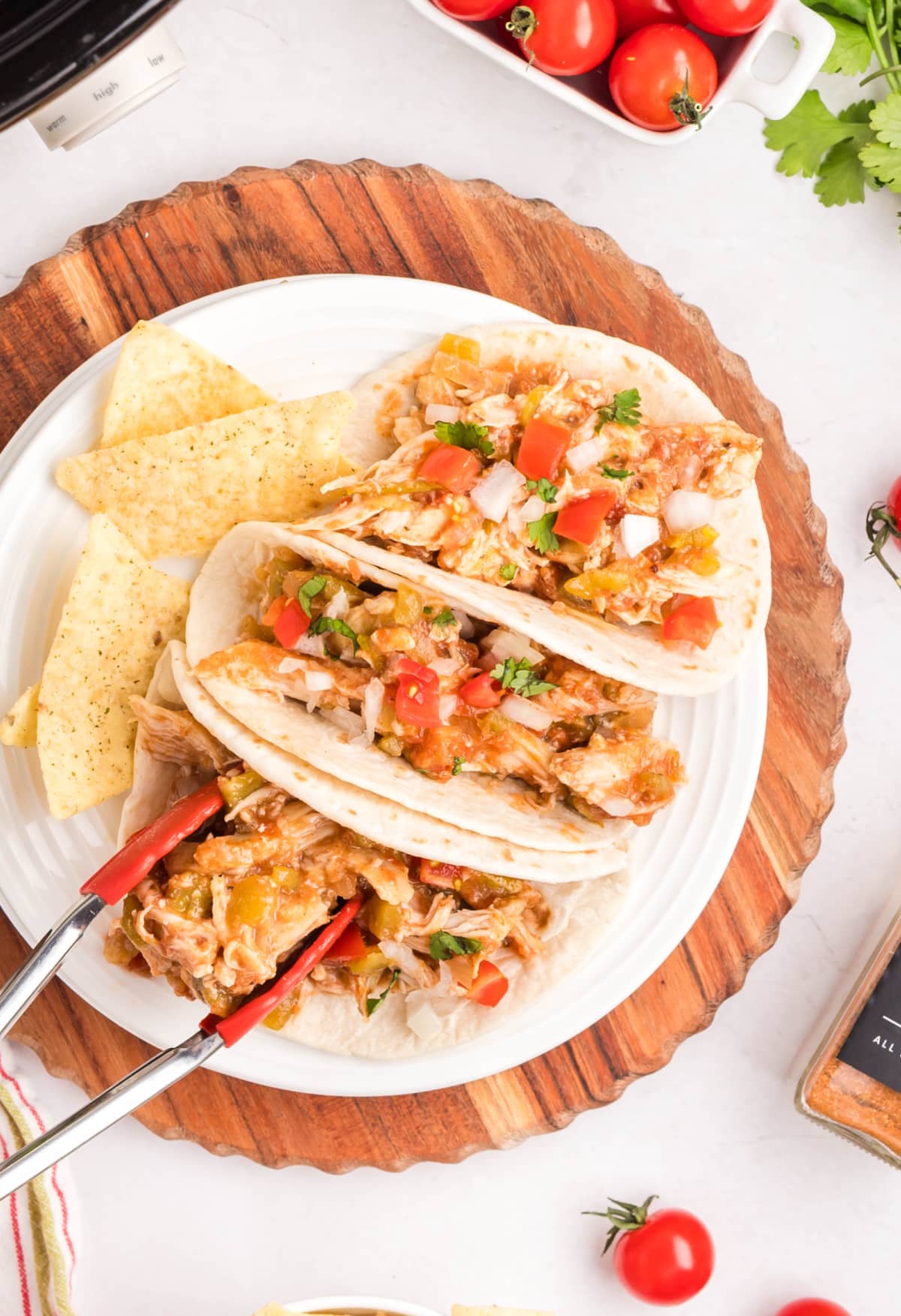 Slow Cooker Shredded Taco Chicken being served Side view of assembled shredded chicken tacos on a plate, ready to serve.