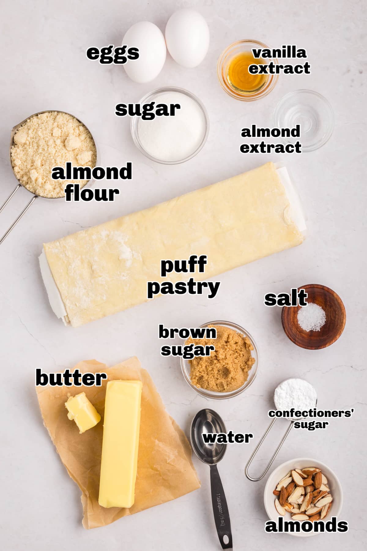 Almond Cruffin ingredients All the ingredients for cruffins displayed on a counter, including puff pastry, almond filling, butter, and sugar.