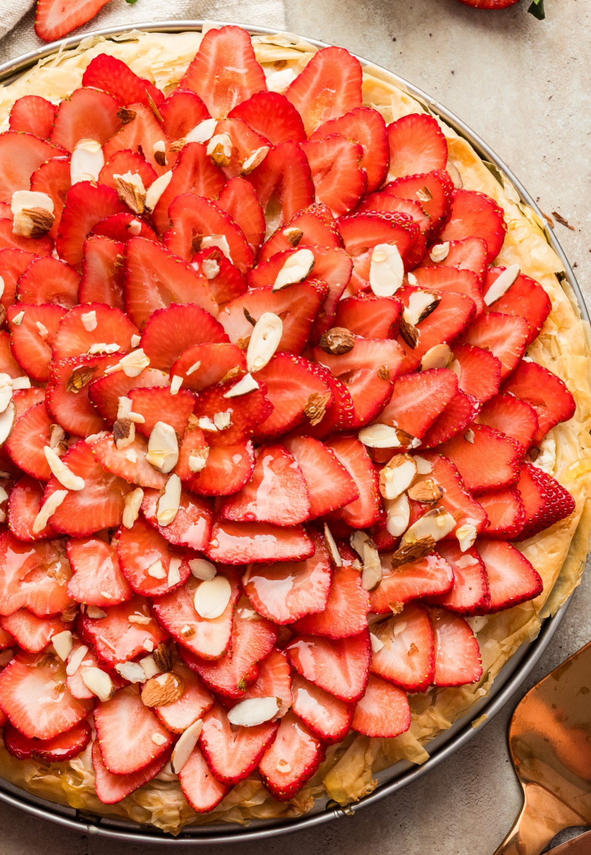 Strawberry Goat Cheese Tart (phyllo dough) Overhead view of a fully assembled strawberry goat cheese tart with phyllo dough on a pizza pan.