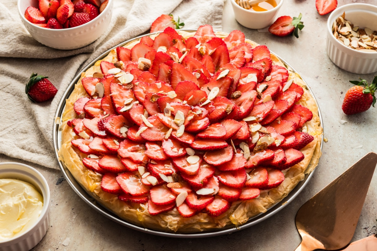Strawberry Goat Cheese Tart (phyllo dough) ready to serve Side angle showing the layered phyllo crust and toppings on the full strawberry goat cheese tart.