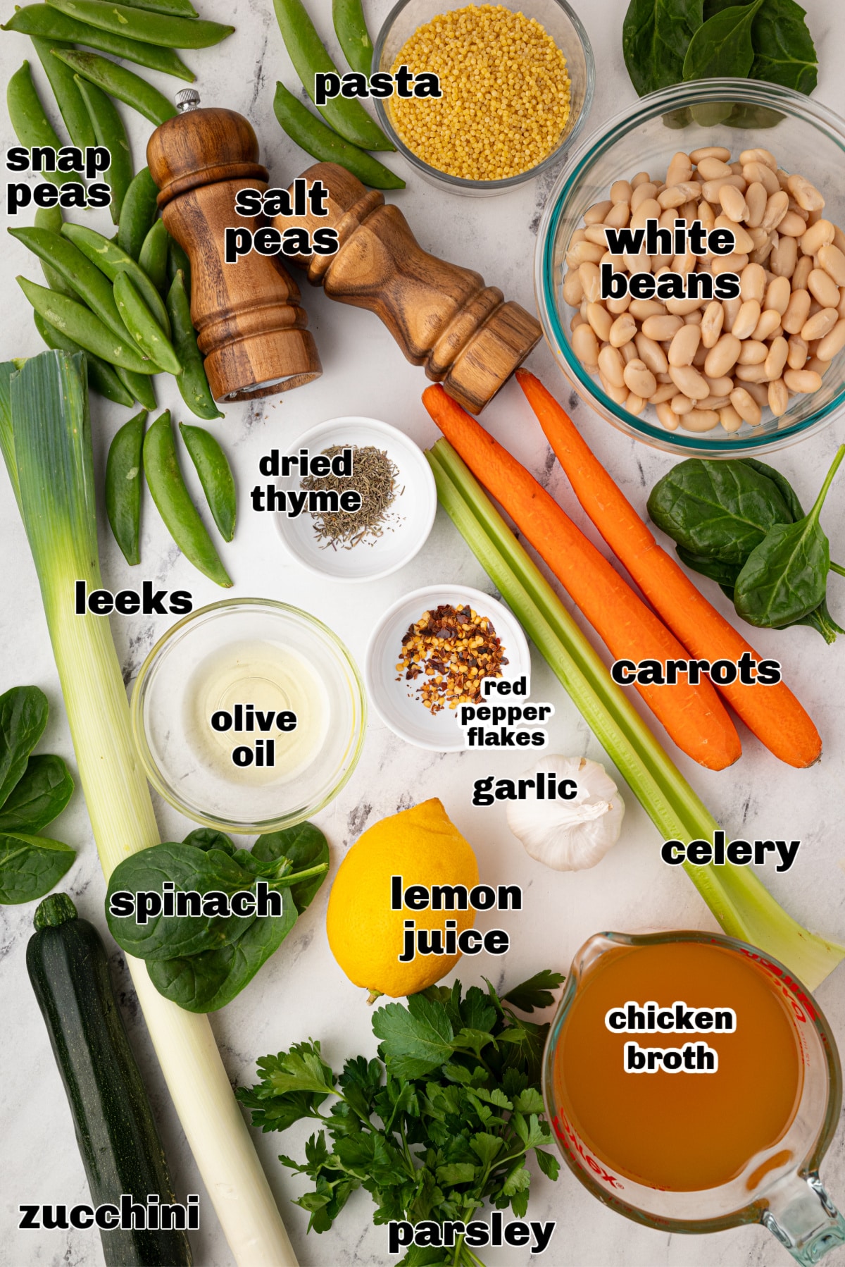 Ingredients for herby green minestrone with lemon and leeks Raw ingredients for green minestrone laid out on a counter, including leeks, lemon, and fresh greens