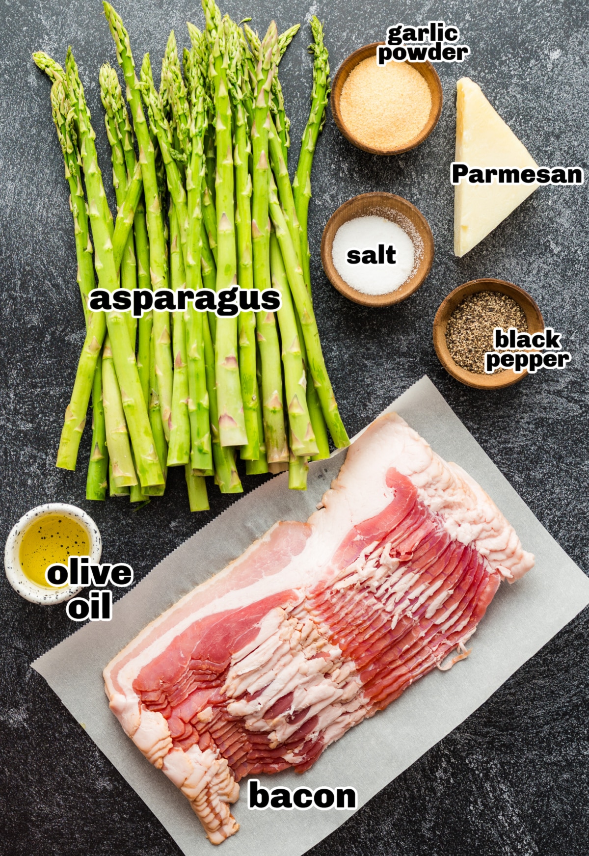 Asparagus, bacon, oil, and seasoning laid out for prepping the recipe Ingredients for bacon-wrapped asparagus arranged on a countertop
